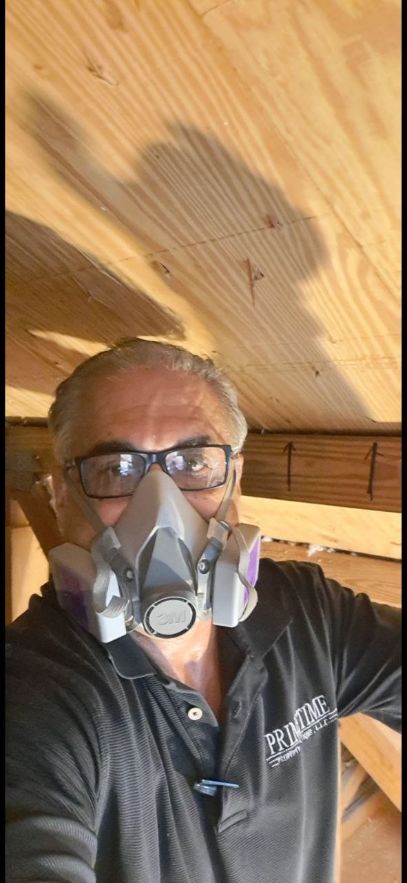 Primetime inspector in attic with respirator checking for mold